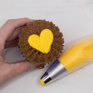 Adding a yellow buttercream face on the lion cupcake. Step 5.