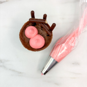 Piping pig head and body with buttercream using large round tip