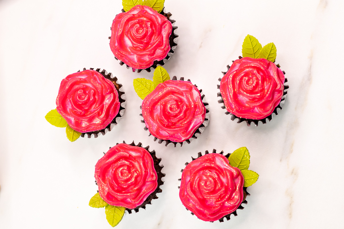 Easy rose cupcakes decorated with two-tone buttercream and chocolate roses, finished with edible glitter and chocolate leaves.