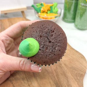 Starting to buttercream frill using pipe and swipe technique around the edge of the cupcake Step 2.