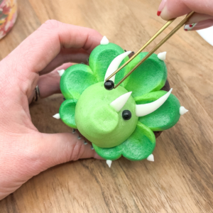 Using tweezers to add black sprinkle eyes. Step 9.