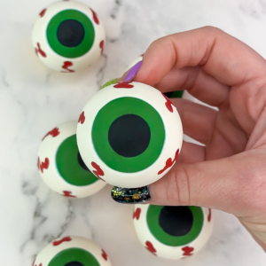 Eyeball cupcakes carefully removed from silicone mold showing detailed iris and pupil. Finished design