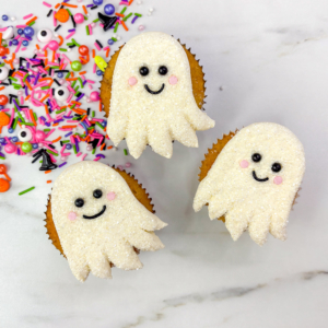 Easy ghost cupcakes decorated with white buttercream, sanding sugar, and candy eyes.