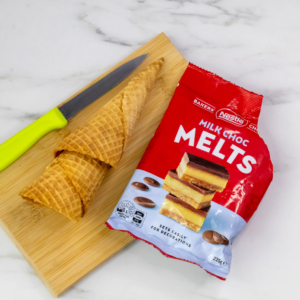 Pack of Nestlé Bakers’ Choice Milk Choc Melts with waffle cones on a wooden board, used for making Sorting Hat cupcakes