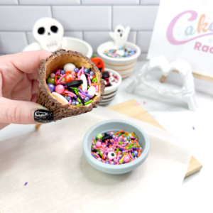 Filling the inside of an upside-down chocolate broomstick with colourful sprinkles.
