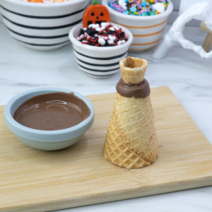 Joined chocolate-coated cones resting on parchment paper to set.