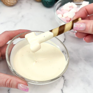 Dipping the wafer bone into melted white chocolate to coat it evenly