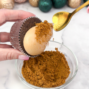 Covering the buttercream with Biscoff crumbs and smoothing the surface