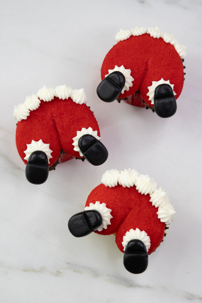 Santa butt cupcakes with red sugar coating, white buttercream trim and black boots