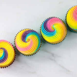 Rainbow swirl cupcakes decorated with pastel pink, peach, yellow, green, blue and purple buttercream.